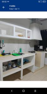 a kitchen with white cabinets and a white sink at 4 soles in San Juan