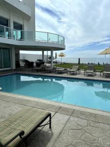 a swimming pool with tables and chairs and a building at ¡Increíble casa frente al mar! in Tijuana
