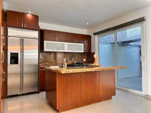 a kitchen with a stainless steel refrigerator and a sink at ¡Increíble casa frente al mar! in Tijuana