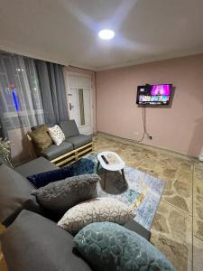 ein Wohnzimmer mit einem Sofa und einem TV in der Unterkunft Acogedor espacio cerca del Metro in Bello