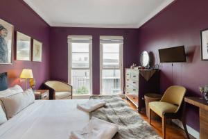 een slaapkamer met paarse muren, een bed en een tv bij Great Gatsby Style in the Heart of Double Bay in Sydney