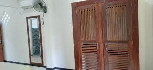 a wooden door in a room next to a mirror at Sunil's Villa in Hikkaduwa
