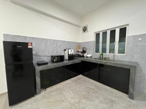 a kitchen with black cabinets and a black refrigerator at FunkyVila4 14PAX 4BR Near188Tower, ArtStreet, HTTA in Kuantan +11 photos