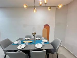 uma sala de jantar com mesa e cadeiras em FunkyVila4 14PAX 4BR Near188Tower, ArtStreet, HTTA em Kuantan