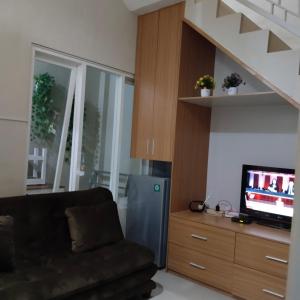 uma sala de estar com um sofá e uma televisão em Villa keluarga sejahtera em Batu
