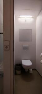 a bathroom with a white toilet and a light at ibis budget Dresden City in Dresden