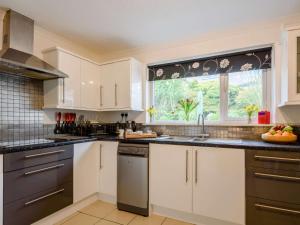 a kitchen with white cabinets and a window at 3 Bed in Harlech 42153 in Harlech