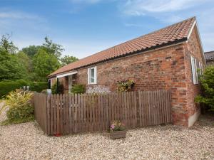 a brick house with a wooden fence in front of it at 2 Bed in Howden G0113 in Saltmarshe
