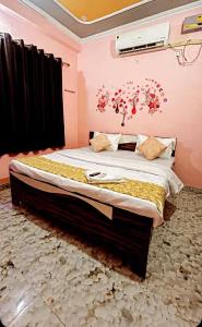 um quarto com uma cama grande com flores vermelhas na parede em HOTEL KRISHNA INN, NAINI em Prayagraj