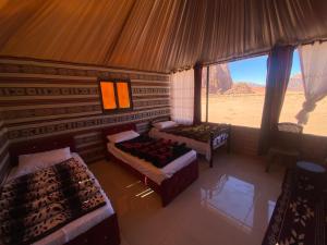 a room with two beds and a view of the desert at Authentic Wadi Rum camp & tours in Wadi Rum