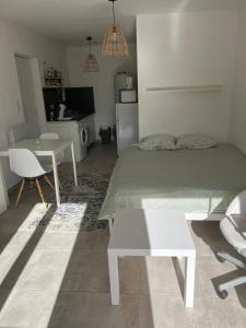 a bedroom with a bed and a table and a dining room at Studio cosy et climatisé - Tout équipé - Parking privé in Roaix +11 photos