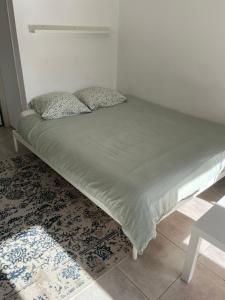 a bed with two pillows on it in a room at Studio cosy et climatisé - Tout équipé - Parking privé in Roaix