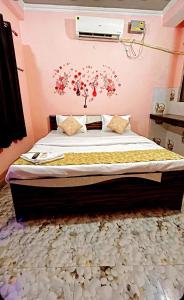 um quarto com uma cama com flores na parede em HOTEL KRISHNA INN, NAINI em Prayagraj