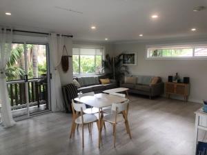 a living room with a table and chairs at Lautan Cronulla Beach in Cronulla