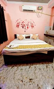 um quarto com uma cama com flores na parede em HOTEL KRISHNA INN, NAINI em Prayagraj