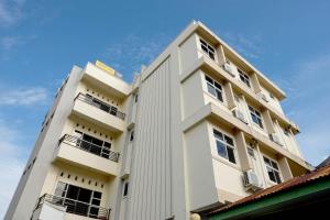 ein weißes Gebäude mit Balkon auf der Seite in der Unterkunft SPOT ON 2610 Zn Guest House in Makassar
