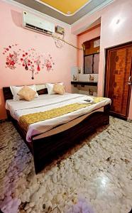 um quarto com uma cama grande com flores na parede em HOTEL KRISHNA INN, NAINI em Prayagraj