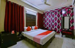 um quarto com uma cama e cortinas vermelhas em COLLECTION O HOTEL SKY INN em Jaipur