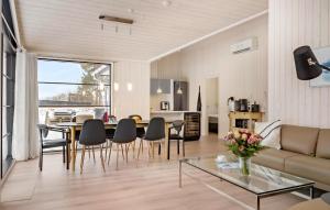 a living room with a couch and a table and chairs at Amazing Home In Ebeltoft With Kitchen in Ebeltoft