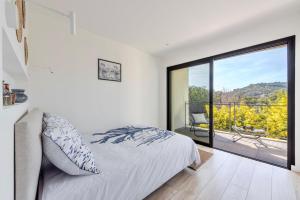 1 dormitorio con cama y ventana grande en Magnifique Appartement Plage Cavalière Terrasse 3 Chambres Garage, en Le Lavandou
