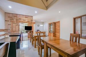 comedor con mesas y sillas de madera en OYO 90319 Angler Guest House Malang, en Malang
