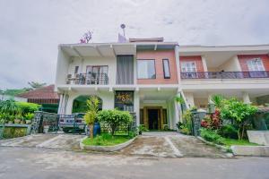 a large house with a driveway in front of it at OYO 90319 Angler Guest House Malang in Malang