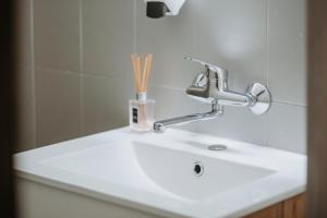 a bathroom sink with a faucet on top of it at Verslo Klasė-easy to stay in Panevėžys