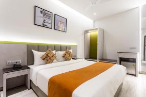 a bedroom with a large bed in a room at FabHotel Prime Oasis Orange in Bhopal