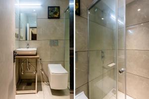 uma casa de banho com um chuveiro, um WC e um lavatório. em FabHotel Prime Oasis Orange em Bhopal