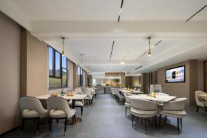寧海的住宿－宁波宁海亚朵酒店，一间设有白色桌椅的用餐室