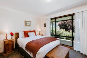 une chambre avec un lit et une grande fenêtre dans l'établissement Ithaca Farm Cottage - Country View Seclusion, à Mudgee