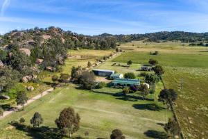 une vue aérienne sur une ferme avec un bâtiment sur une colline dans l'établissement Ithaca Farm Cottage - Country View Seclusion, à Mudgee