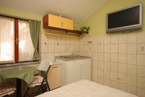 a small kitchen with a sink and a tv on the wall at Apartments by the sea Split - 7602 in Split