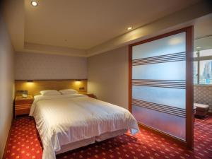 Rúm í herbergi á Rich & Free Hotel - Fuzhong 富逸旅趣-板橋府中館