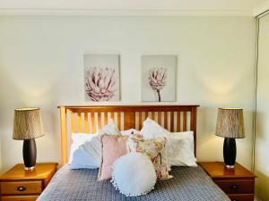 a bedroom with a bed with two lamps at Blue Poles - Pet Friendly in Robe