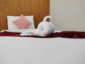un animal de toalla blanca sentado en una cama en S2S Queen Trang Hotel, en Trang
