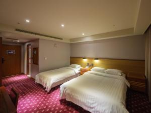 Rúm í herbergi á Rich & Free Hotel - Fuzhong 富逸旅趣-板橋府中館