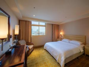 Rúm í herbergi á Rich & Free Hotel - Fuzhong 富逸旅趣-板橋府中館