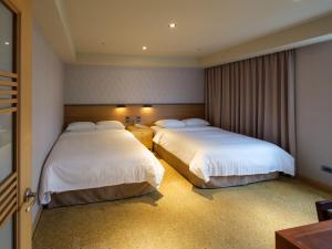 Rúm í herbergi á Rich & Free Hotel - Fuzhong 富逸旅趣-板橋府中館
