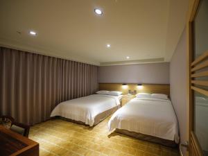Rúm í herbergi á Rich & Free Hotel - Fuzhong 富逸旅趣-板橋府中館