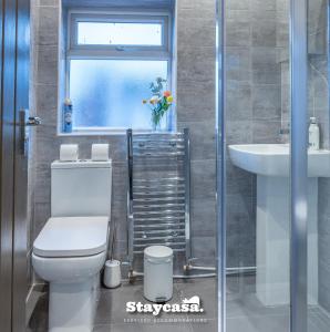 La salle de bains est pourvue de toilettes, d'un lavabo et d'une fenêtre. dans l'établissement Urban Comfort 4-bed House - Free Wi-fi & Parking, à Manchester