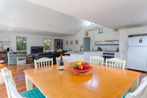 a table with a bowl of fruit on it in a kitchen at Stroll to the Sea - Sun-drenched Seaside Lifestyle in Rye
