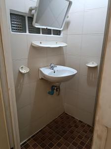 La salle de bains est pourvue d'un lavabo et d'un miroir mural. dans l'établissement ML rental Battambang, à Battambang