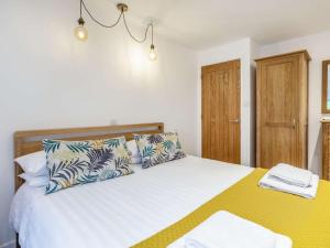 a bedroom with a large white bed with pillows at 2 Bed in Woolacombe 60443 in Bittadon