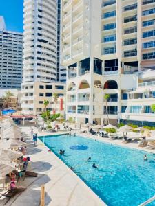 a swimming pool in front of some tall buildings at Hotel Torres Gemelas 2011 N in Acapulco