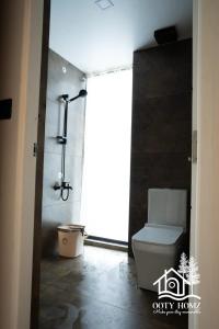 a bathroom with a shower and a toilet in a room at OOTYHOMZ LUXURY STAY in Ooty