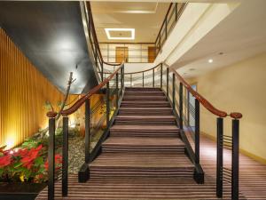 una escalera en un edificio con barandillas de madera en Rich & Free Hotel - Fuzhong 富逸旅趣-板橋府中館 en Taipéi