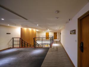 台北的住宿－Rich & Free Hotel - Fuzhong 富逸旅趣-板橋府中館，带有楼梯的办公大楼的走廊