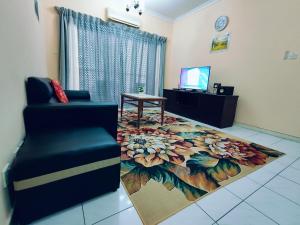- un salon avec une chaise et un tapis de fleurs dans l'établissement Marina Court Resthouse KK, à Kota Kinabalu