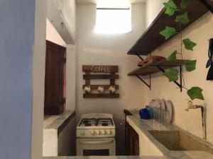 a kitchen with a white stove and a sink at El bungaló in Tecolutla